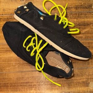 TOMS stud black tennis shoe. Neon yellow strings. Size 9